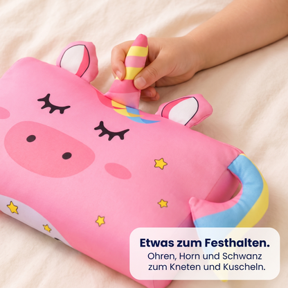 Kinderhand hält das Horn des Einhorn-Kissens